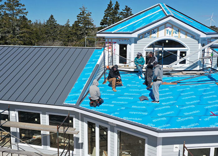 KLAD installing a metal roofing on new construction.