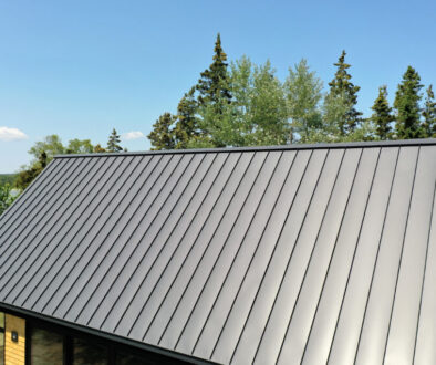tanding seam metal roof panel showing oil canning waviness in sunlight